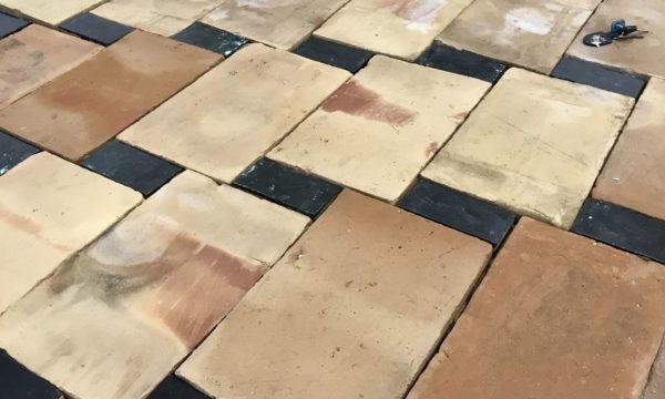 salvaged terracotta tiles with black rectangle floor tiles