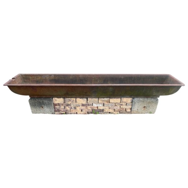 Antique cast iron trough on stone