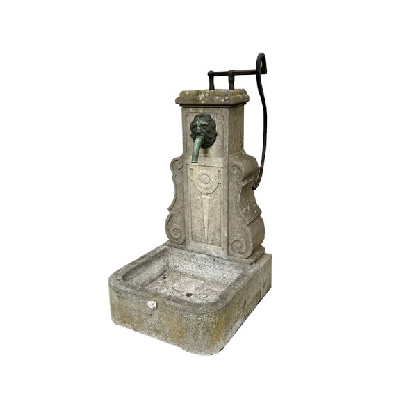 Antique stone wall fountain with hand pump