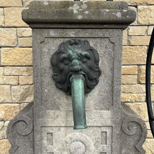 Antique wall fountain with his spout