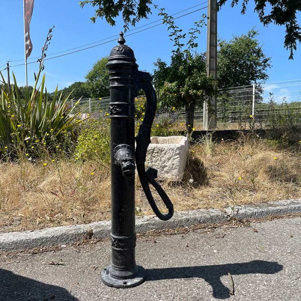 Old cast iron water pump, black and elegantly adorned